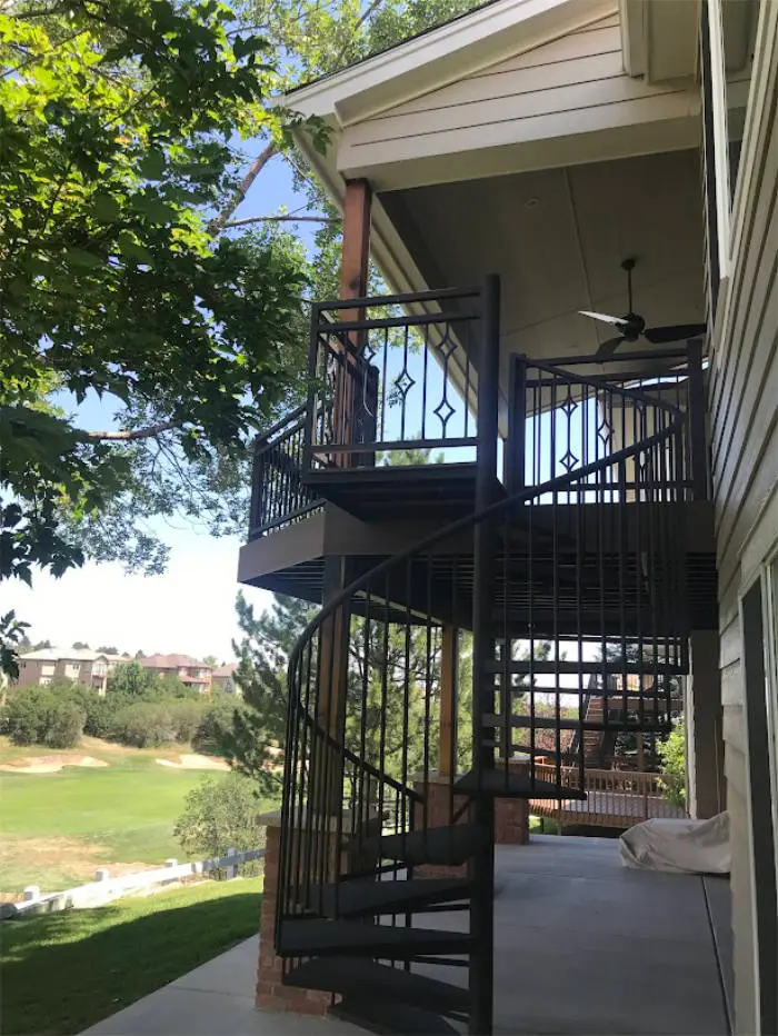 Black spiral staircase beside a covered upper deck with a golf course view