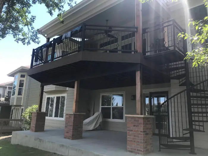 Upper deck with dark railing, brick-base posts and a spiral staircase